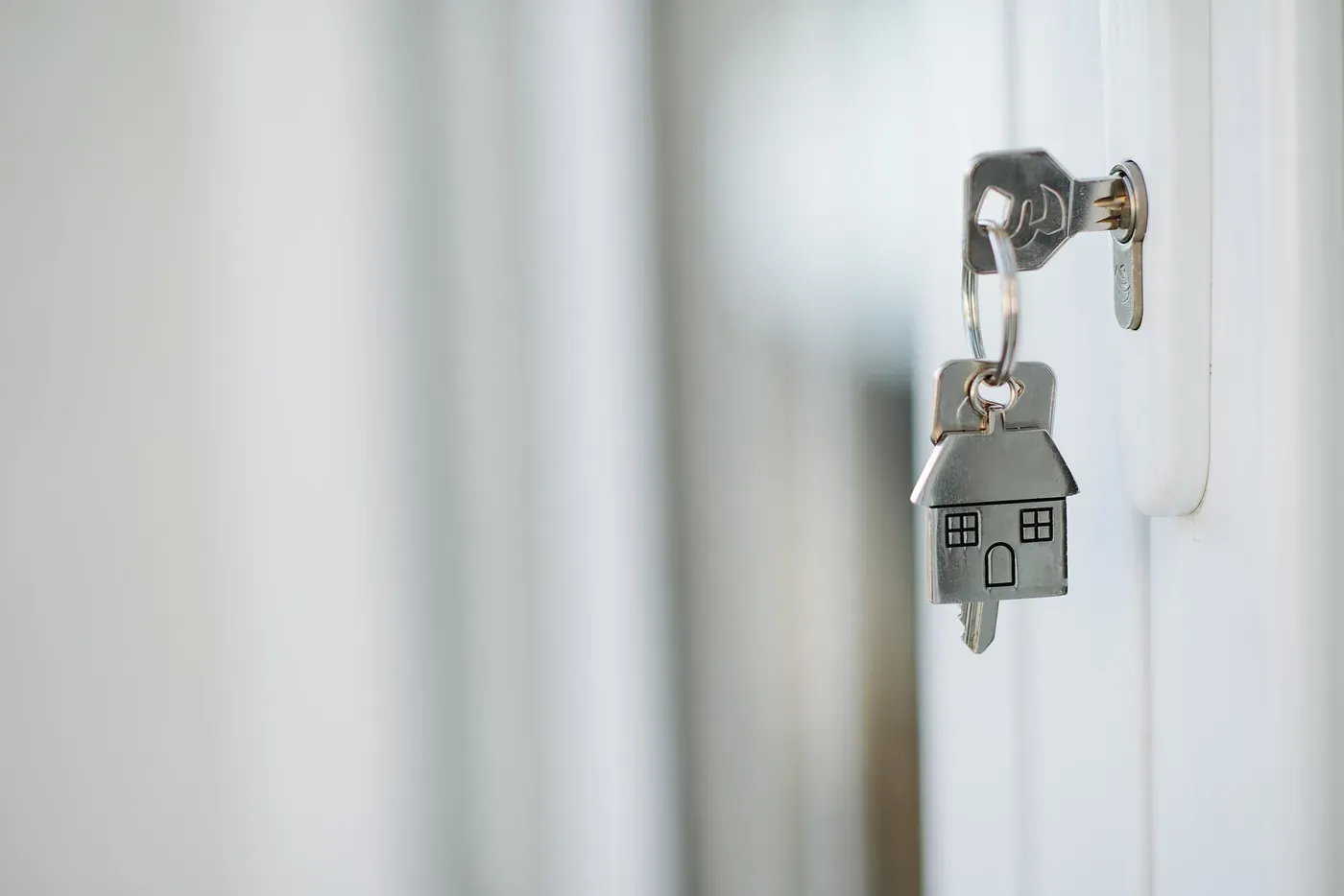 Key and house-shaped key ring in a door lock